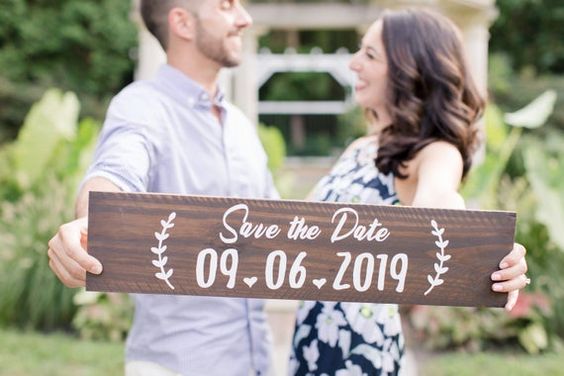 casal segurando placa de save the date