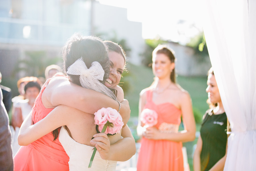madrinha abraçando a noiva em saída do cortejo de casamento