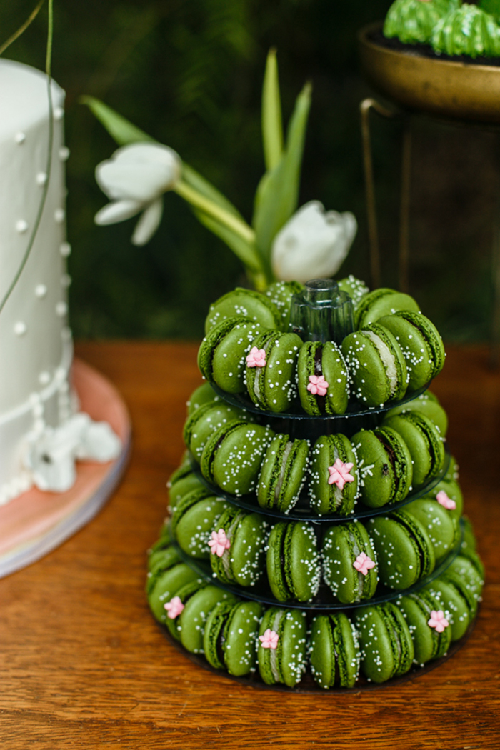 macarons verdes empilhados em mesa de doce de casamento