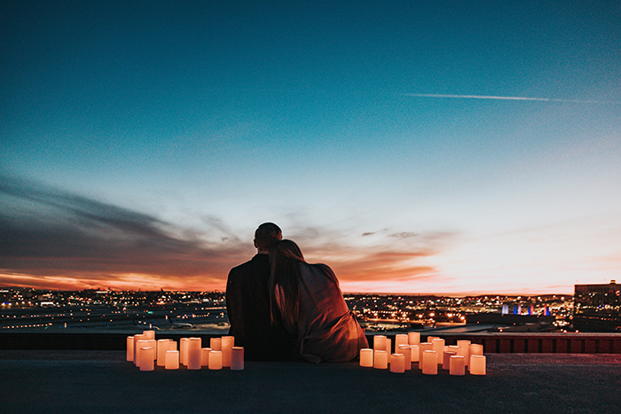 casal em lua de mel apreciando a paisagem com velas ao redor