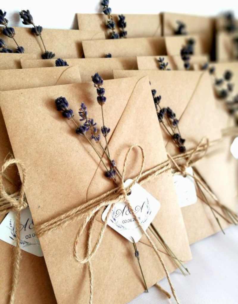 convite de casamento com envelope de papel kraft fita de sisal e ramos de flores