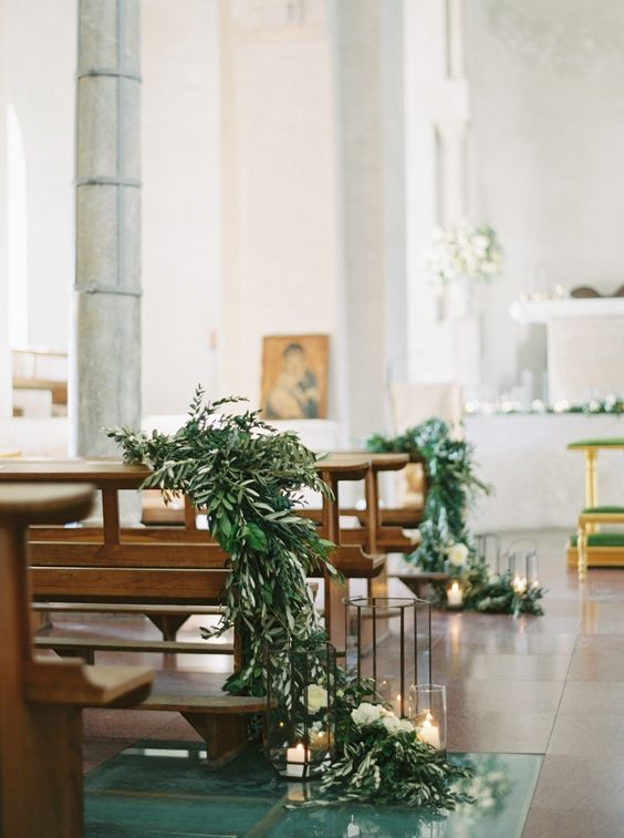  decoração de casamento na igreja com folhagens e velas nos bancos