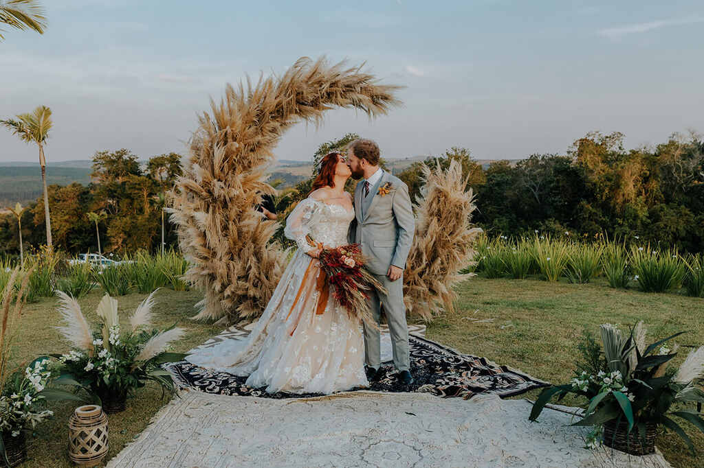 noivos se beijando em altar de capim dos pampas