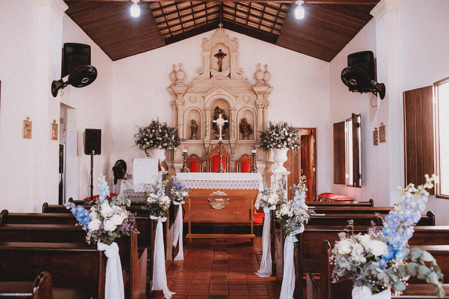 casamento na igreja com bancos decorados com tecidos e flores