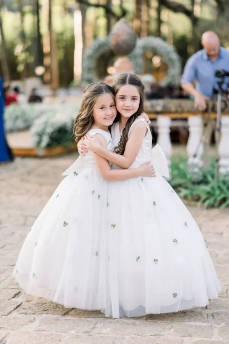 daminhas abraçadas em casamento no campo