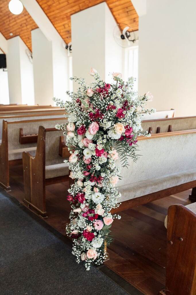 decoração de casamento na igreja adventista com arranjos de flores nos bancos