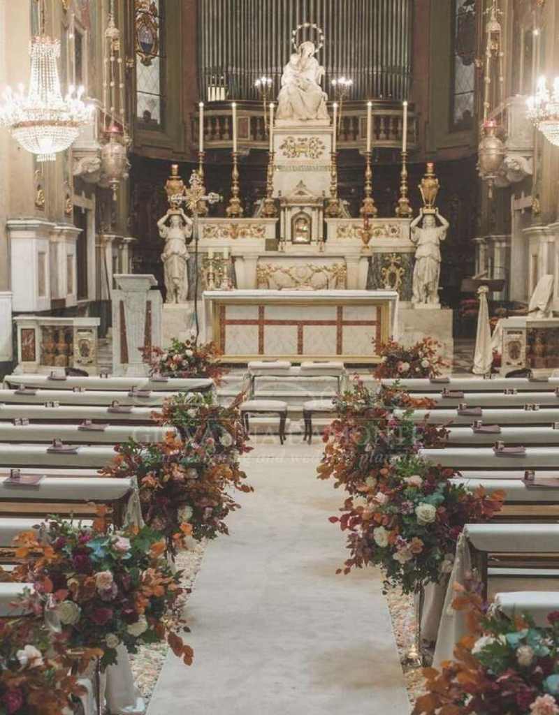 decoração de casamento na igreja católica com arranjos de flores nos bancos