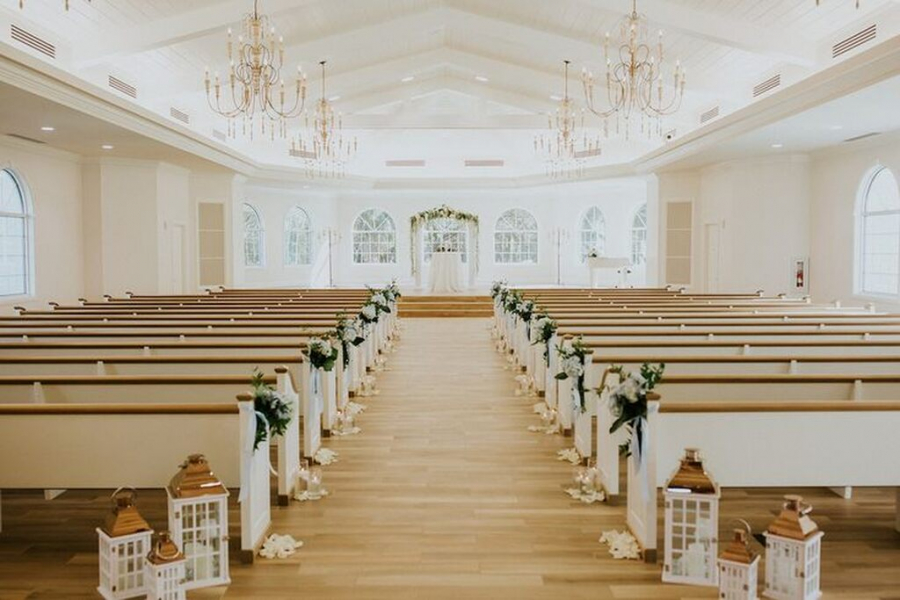 decoração de casamento na igreja evangélica com arranjos de flores brancas nos bancos