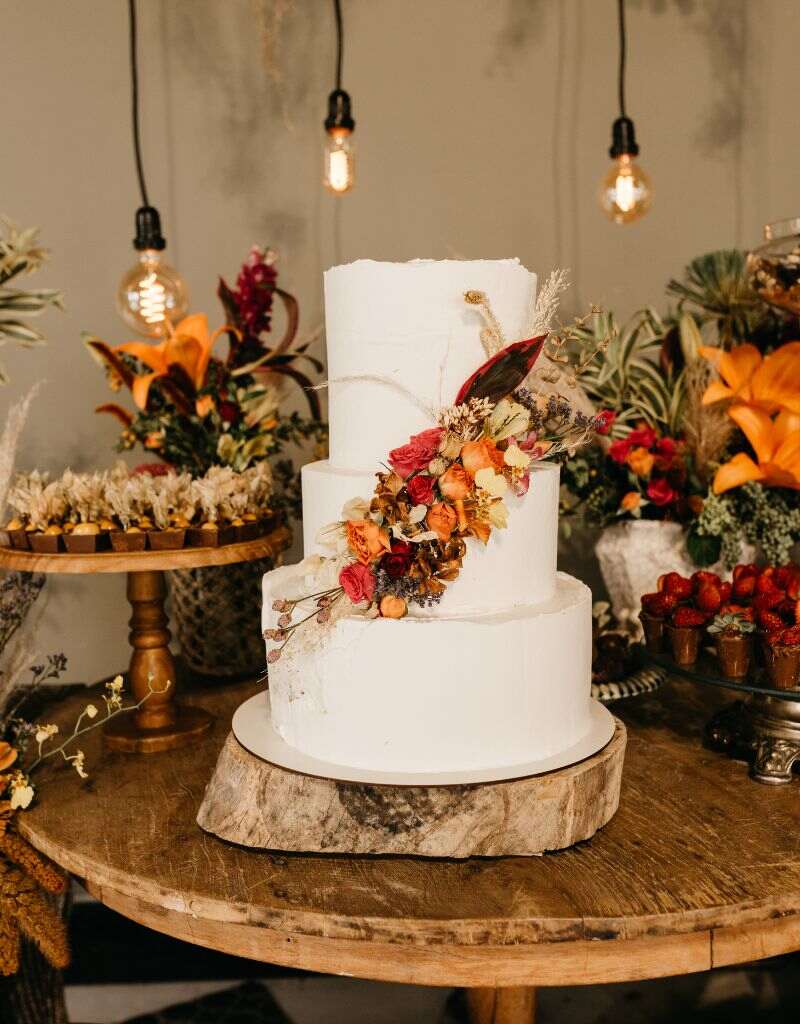 bolo de casamento no campo com flores