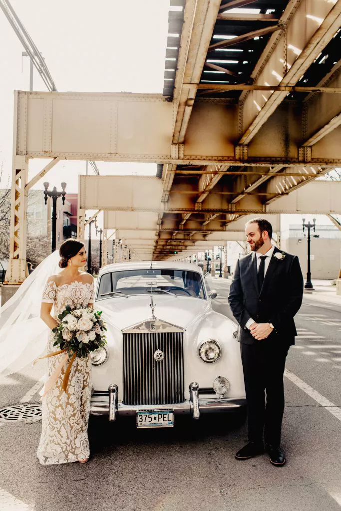 noivos em casamento urbano com carro vintage