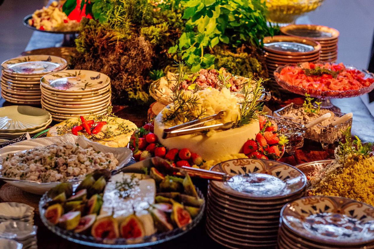 Mesa com queijos, pratos e frutas