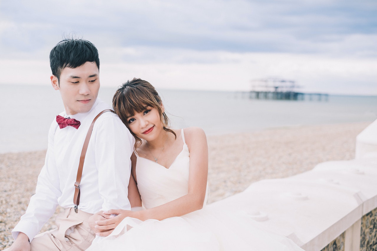 Casal asiático abraçado na praia