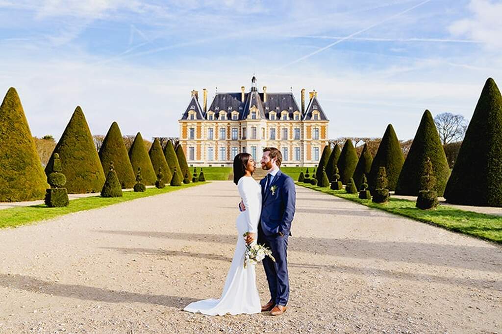 noivos em destination wedding em Paris em frente a um castelo