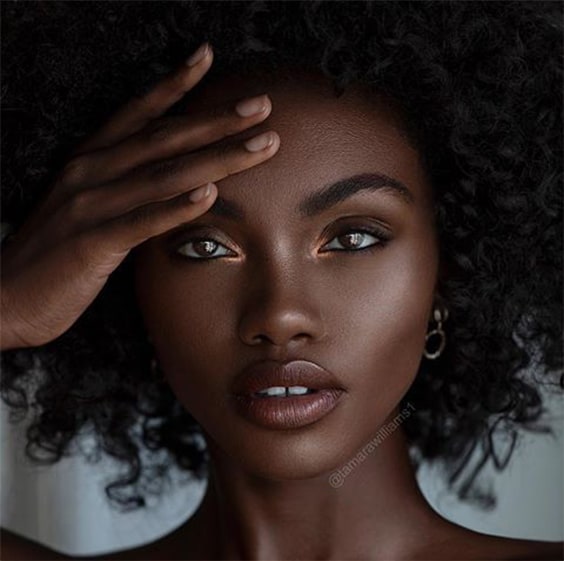 Mulher negra com maquiagem efeito glow