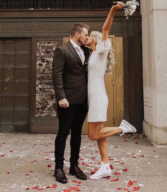 noiva beijando noivo usando sapato de noiva com tênis