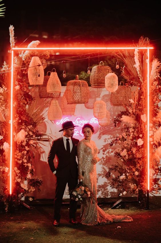noivos com painel com letreiro neon para iluminação de casamento