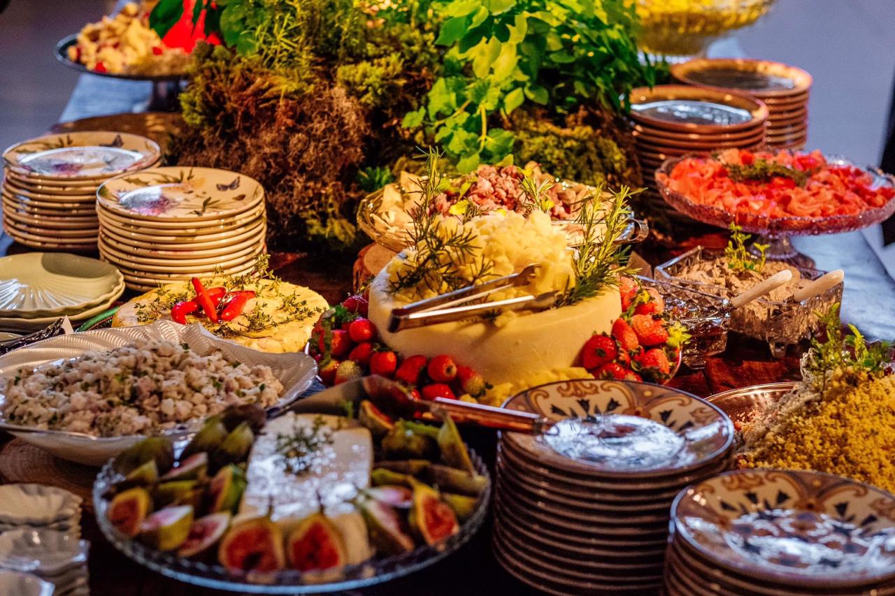 Mesa com pratos estampados e porções de queijo e legumes