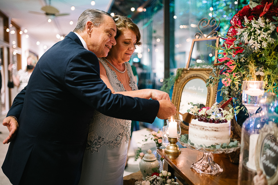 casal cortando bolo em bodas de ouro