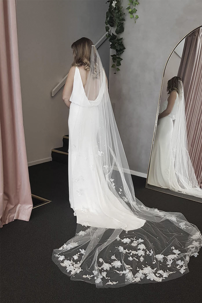 vestido de noiva aberto nas costas e véu de noiva longo com bordados