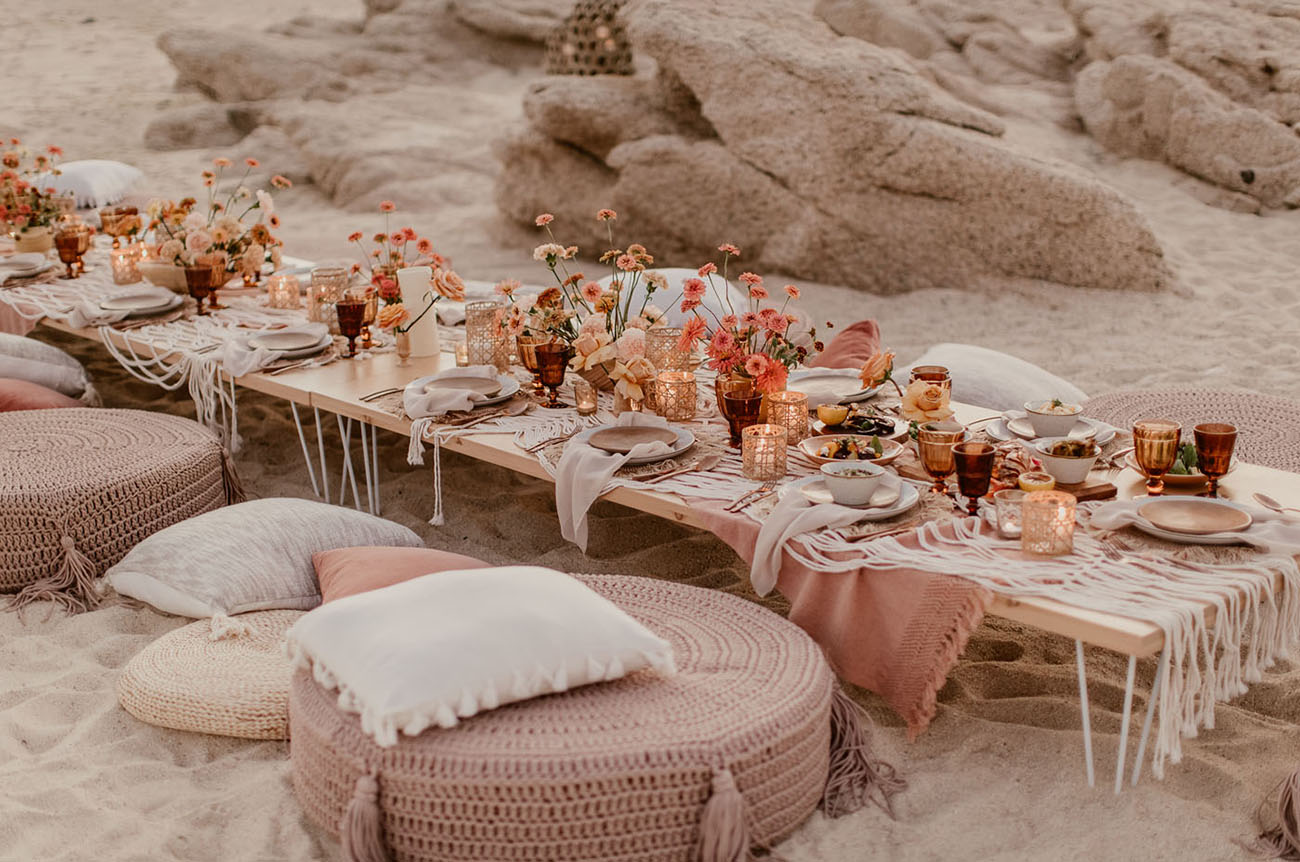 casamento boho na praia com mesa e almofadas no chão