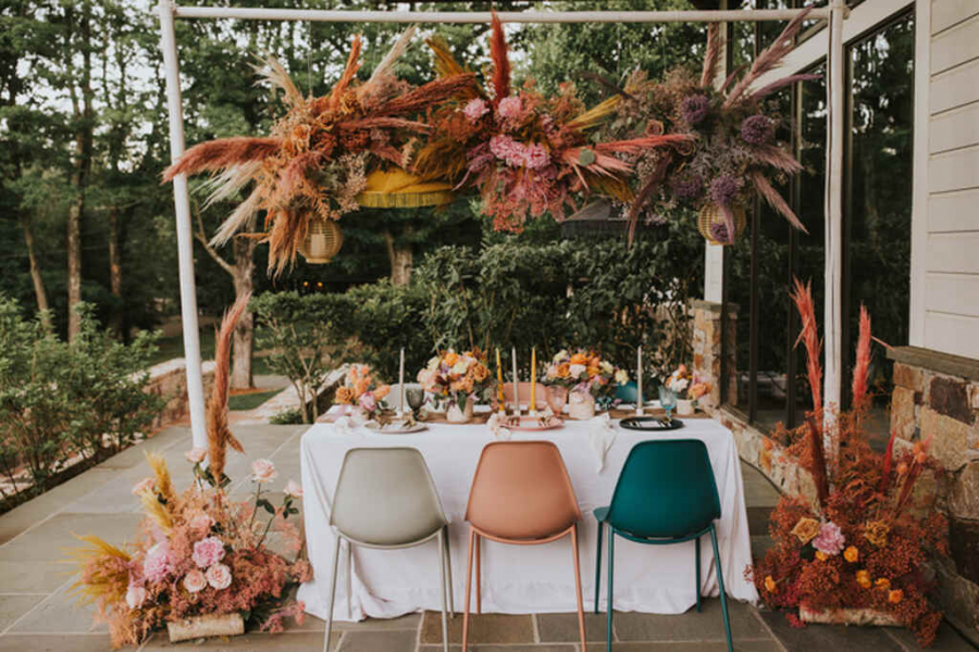 mesa posta com arranjos suspensos com folhagem colorida em casamento intimista