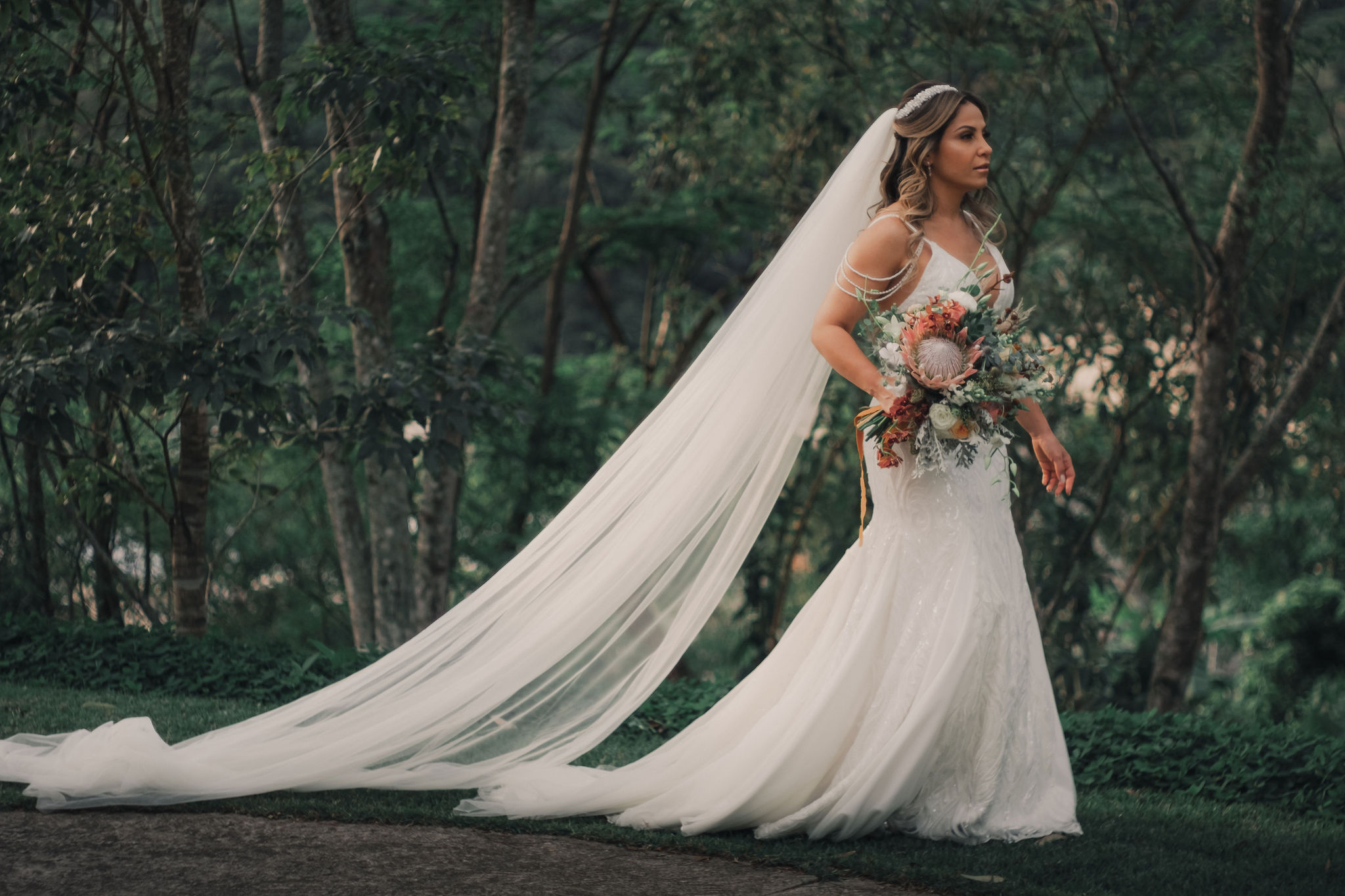 Mulher com vestido de noiva e véu na floresta