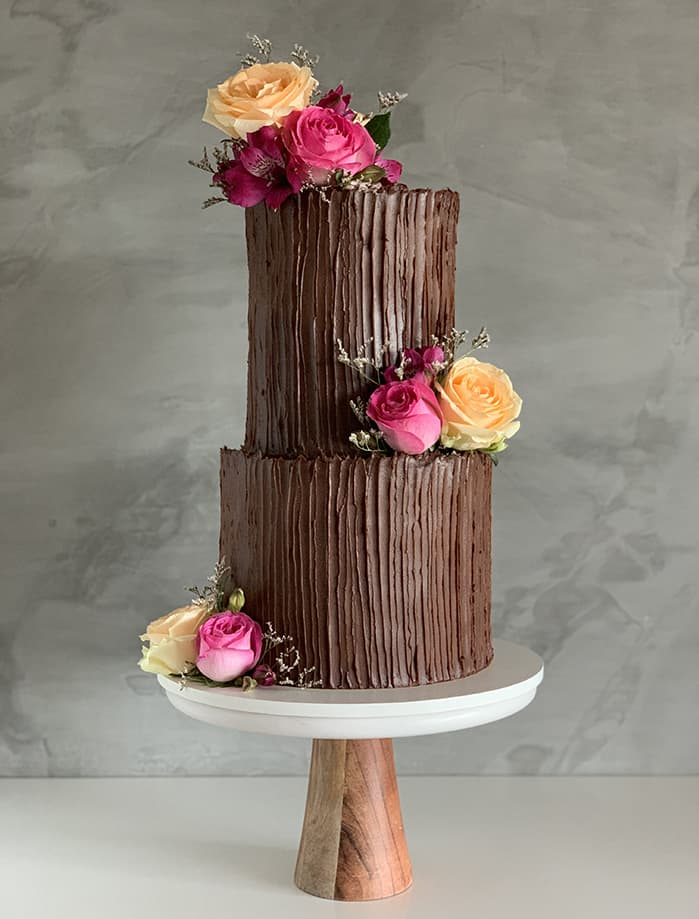 Bolo de casamento de chocolate e flores rosas