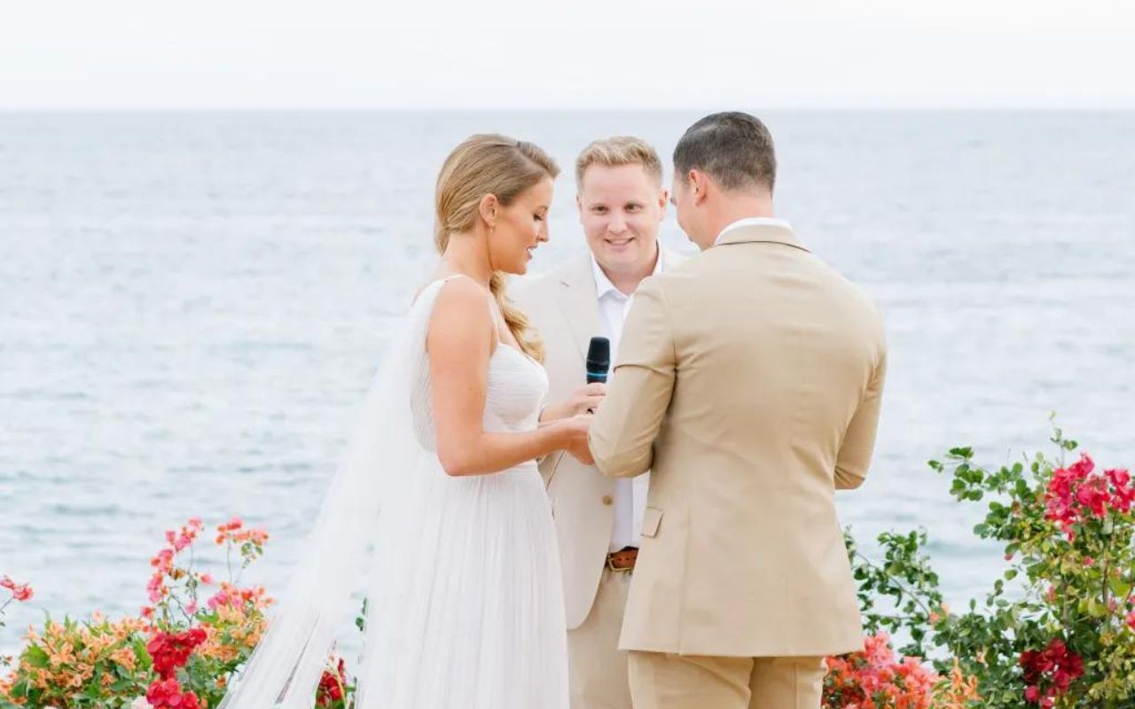 momento de troca de alianças durante cerimônia de casamento ao ar livre na praia em frente ao mar