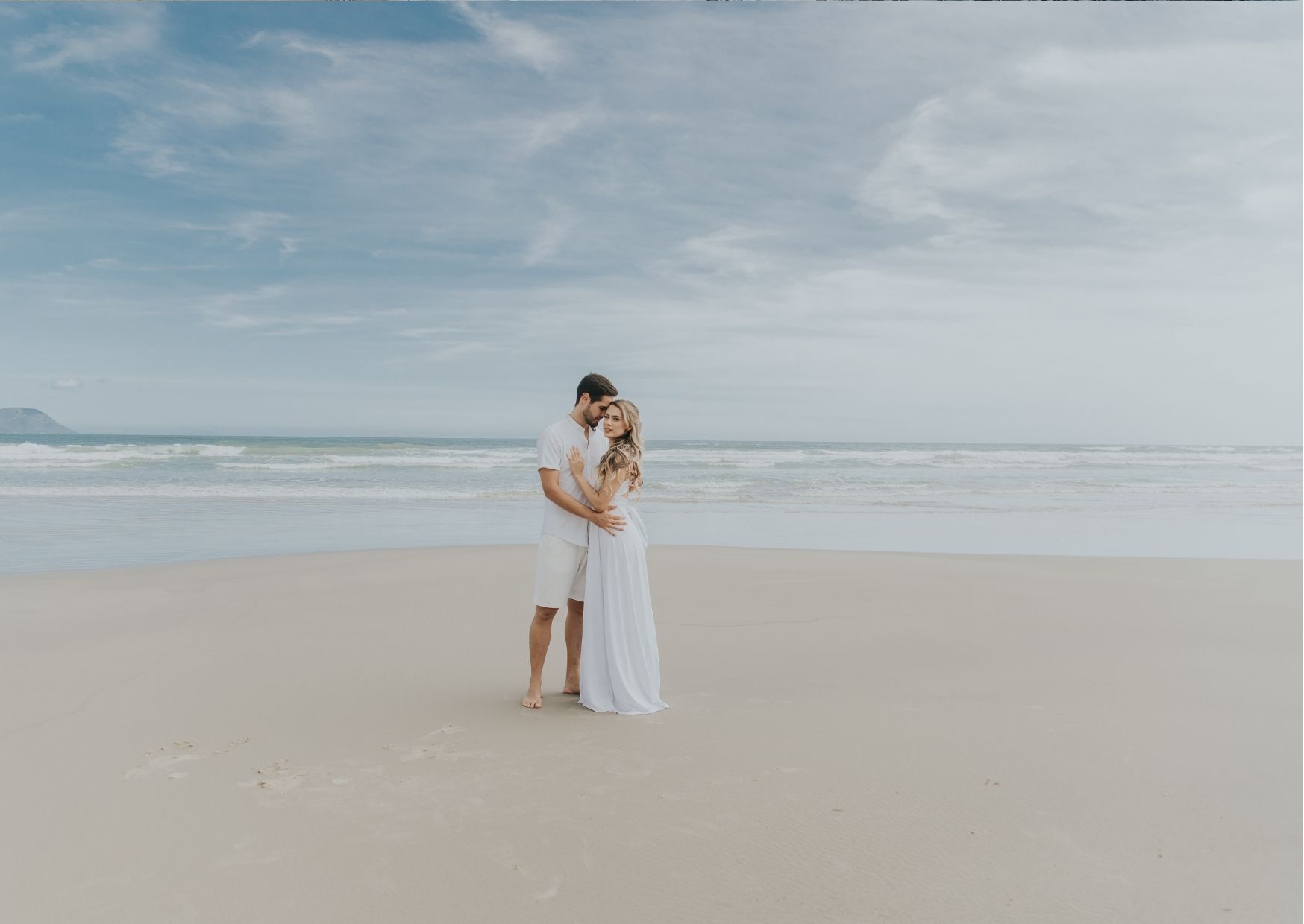 Casal se abraçando na praia
