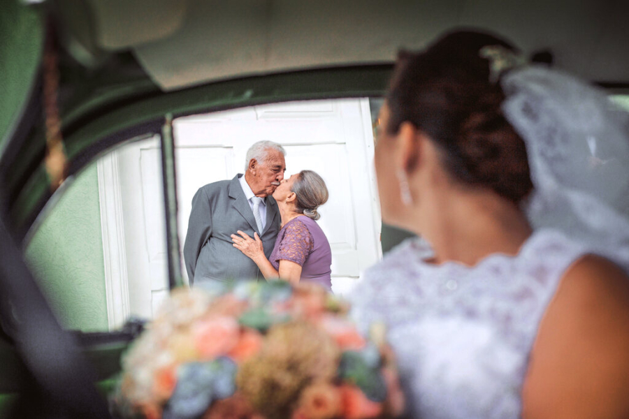 Noiva dentro do carro vendo avós se beijando na calçada