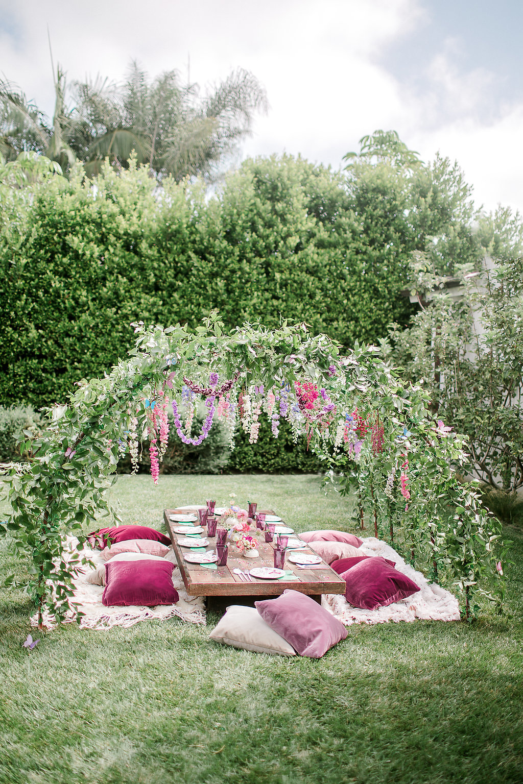 arco decorativo com almofadas no chão em casamento no jardim