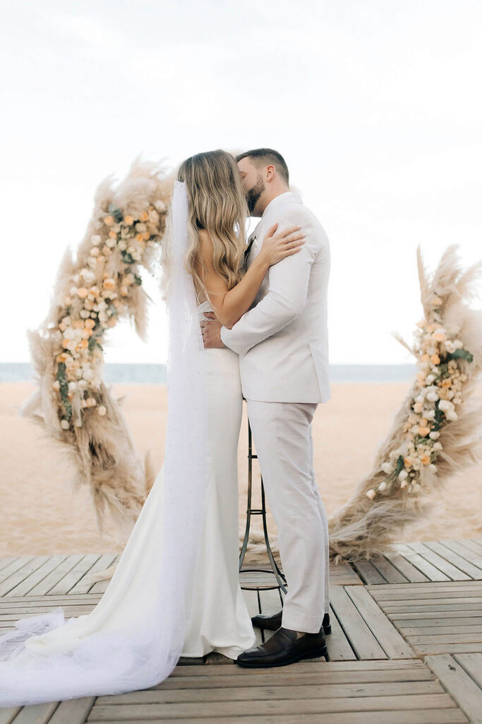 beijo dos noivos em casamento na praia