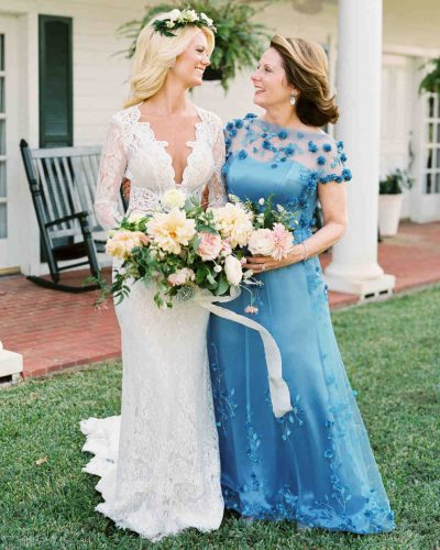mãe com vestido azul ao lado da noiva