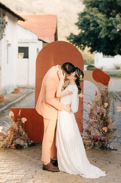 casal em frente ao altar terracota e rosa
