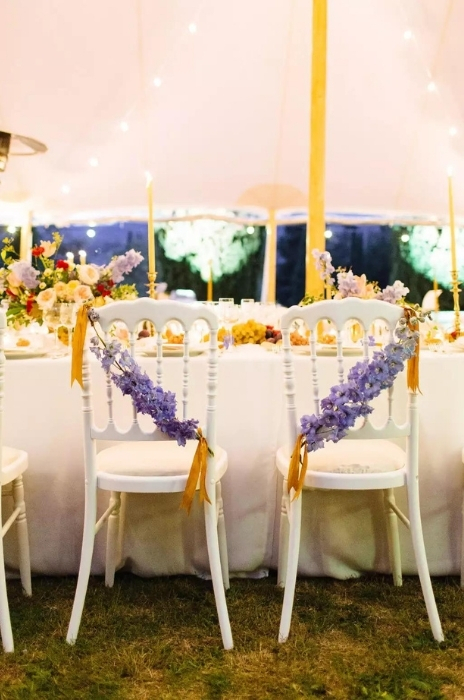 cadeiras brancas com flores roxas para casamento vintage ao ar livre