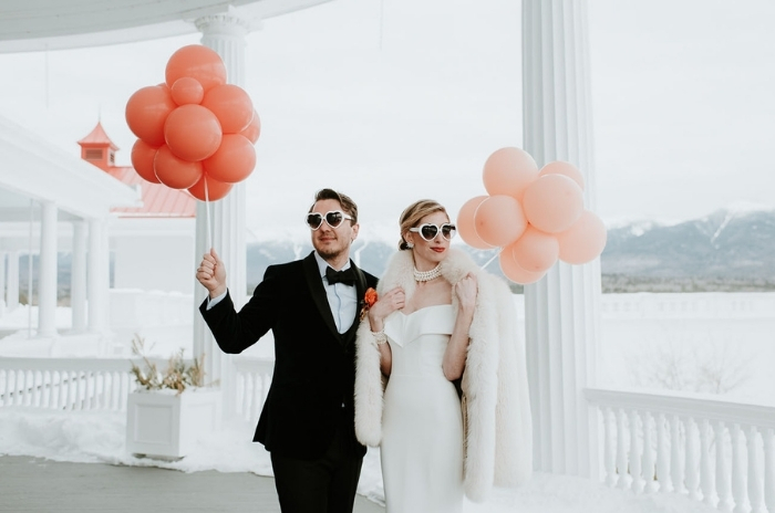 noivos com óculos escuros segurando balões em casamento vintage