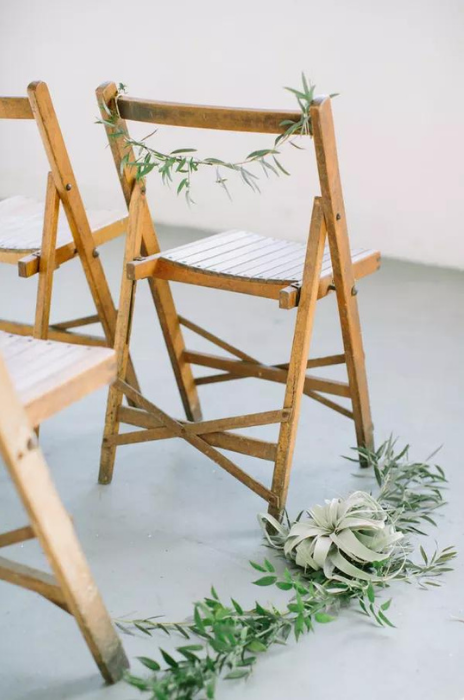 cadeira de madeira decorada com folhas em casamento minimalista