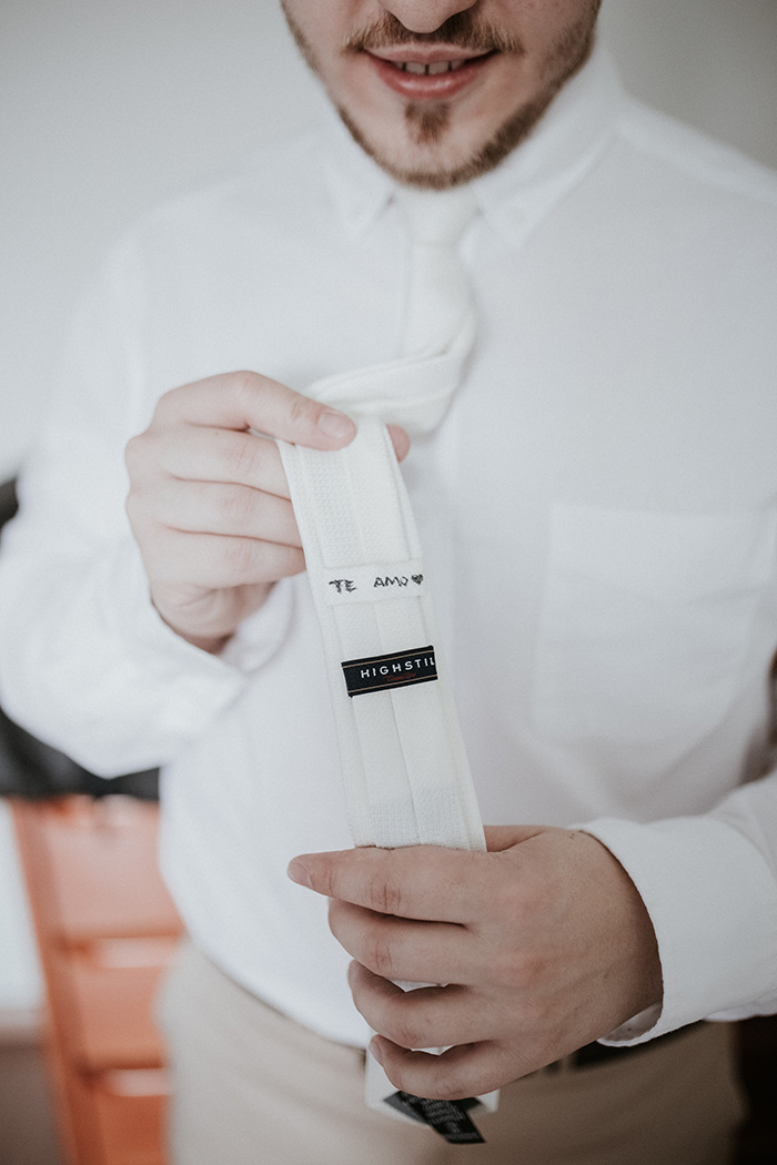 Noivo mostrando gravata branca