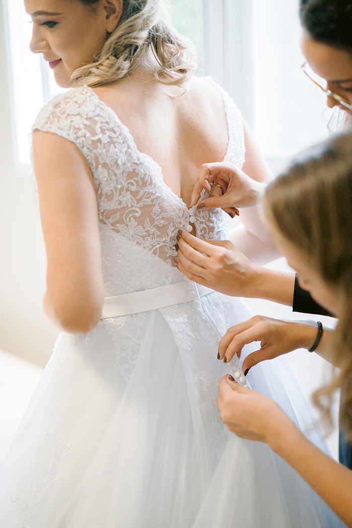 Mulheres ajustando vestido da noiva