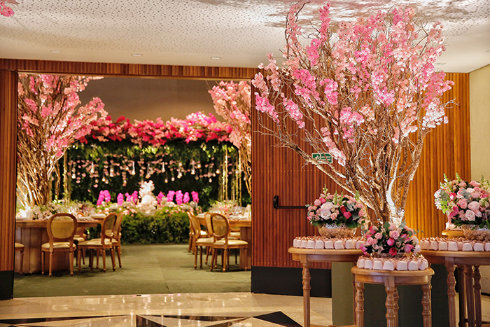 Salão de festas com mesa e árvores floridas