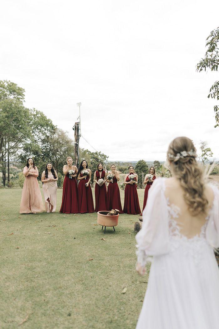 Madrinhas com vestido vermelho olhando a noiva