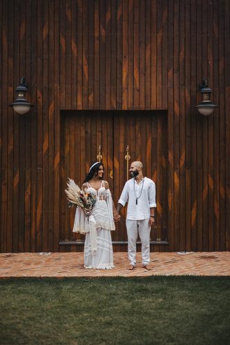 capa post: Noivos de mãos dadas em frente a salão de madeira