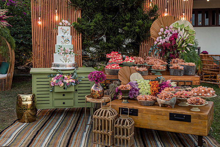 Mesa com bolo doces e flores coloridas