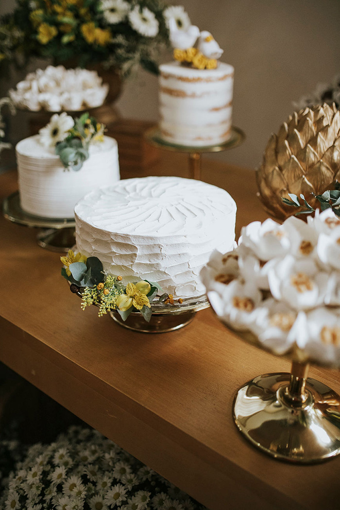 Mesa com bolos brancos de casamento