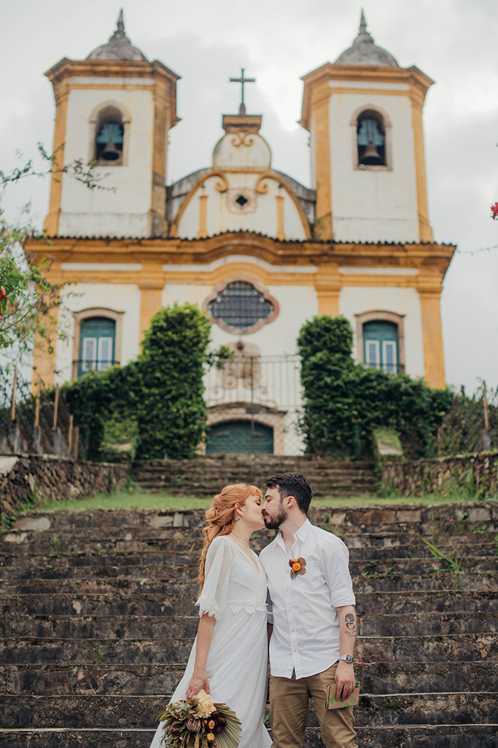 noivos se beijando em frente a igreja
