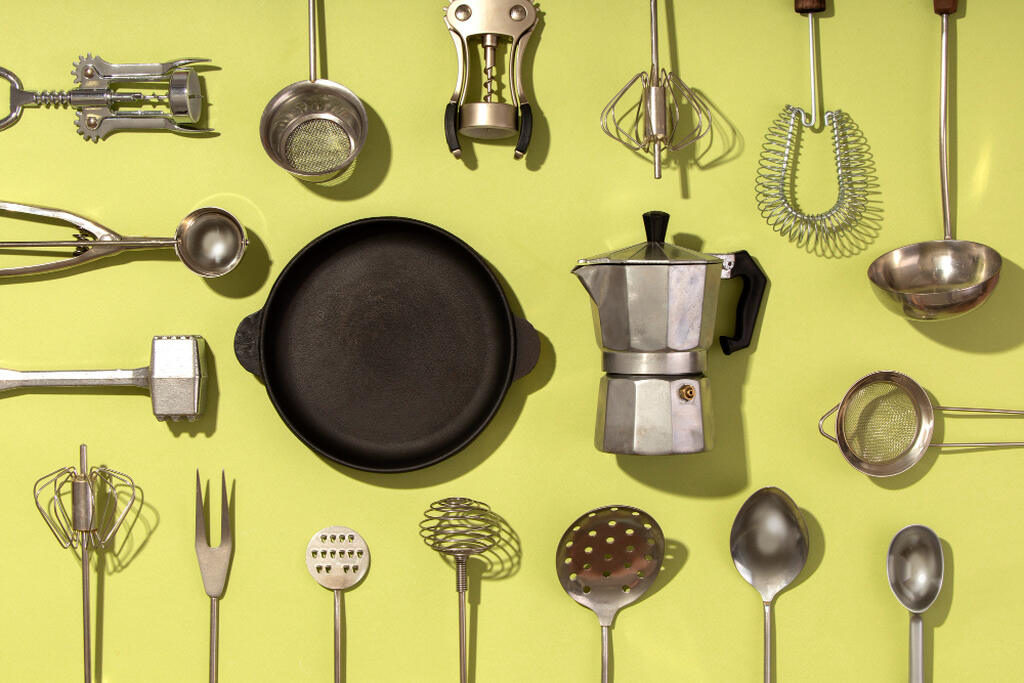 utensilios de cozinha e panela preta de ferro e cafeteira italiana sobre fundo amarelo