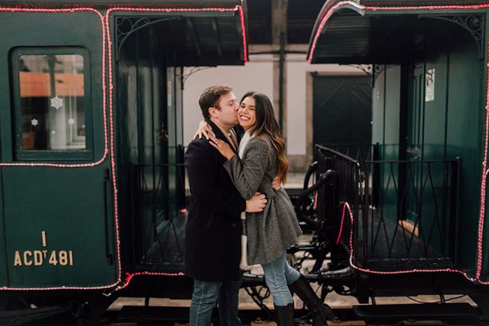 Homem beijando rosto de mulher perto do trem