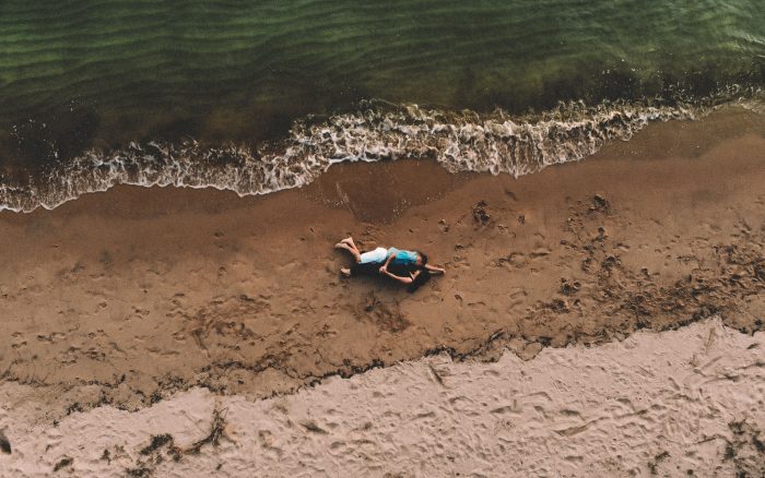 Casal deitado na areia da praia