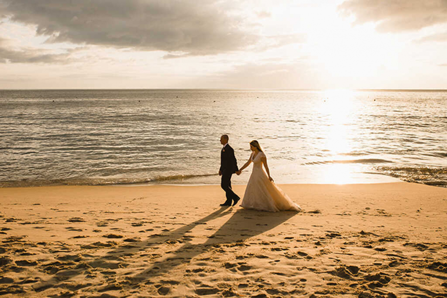 noivos caminhando ao por do sol em casamento na praia