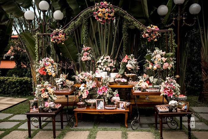 Mesa com flores brancas e rosas e bolos
